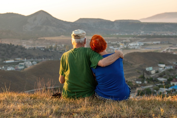 elderly couple sitting on a mountain